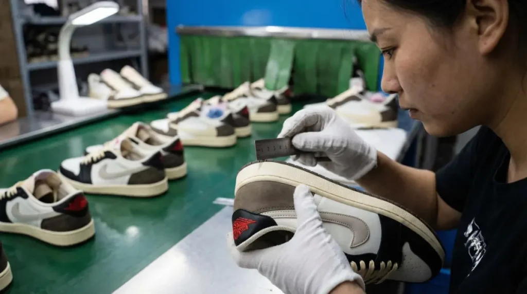 A close-up of a quality control inspector at a Chinese shoe factory meticulously checking the stitching on a sneaker with a ruler.